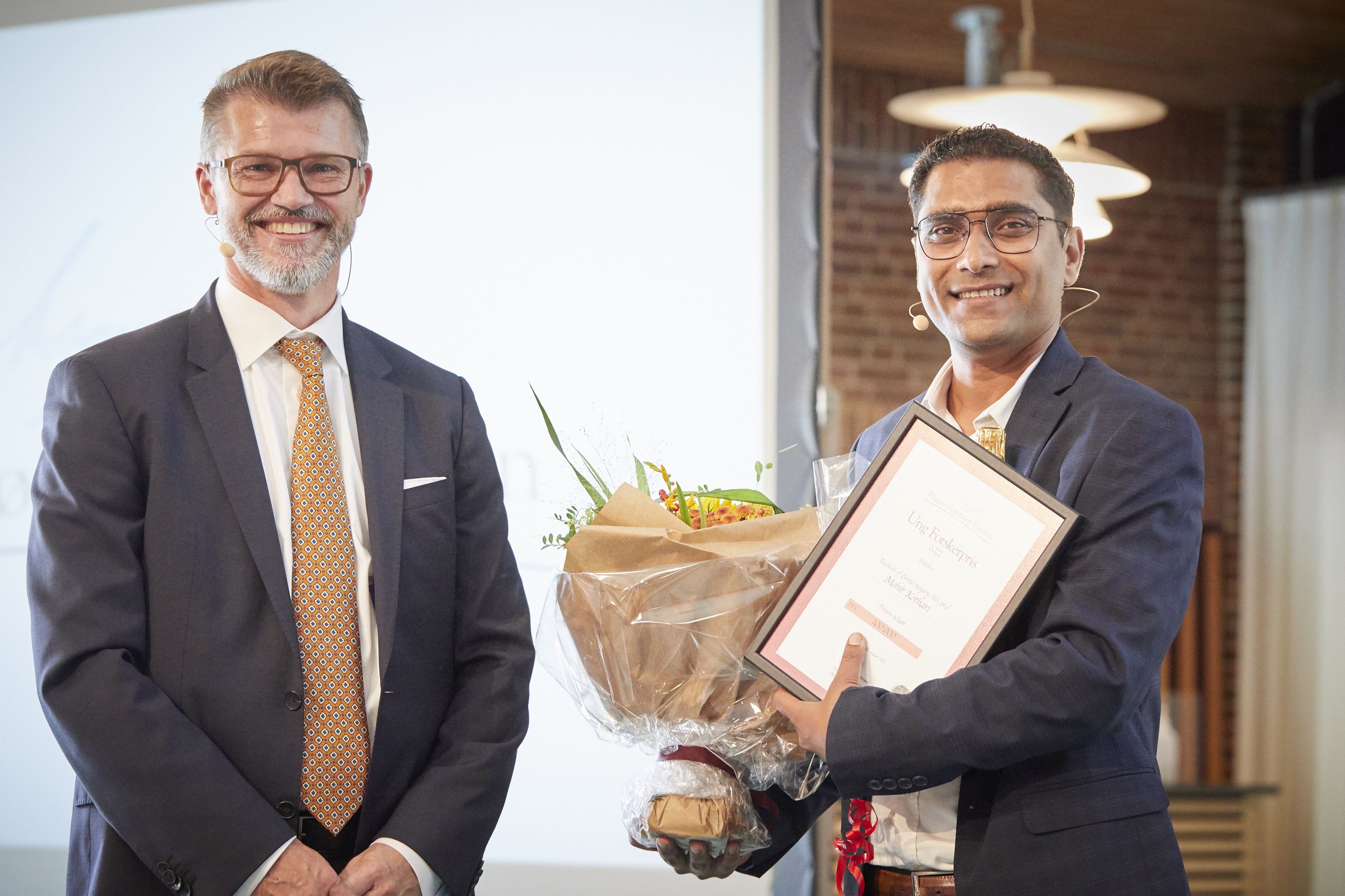 På billedet ses formand for fondens bestyrelse Claus Bagger-Sørensen (til venstre) og vinder af Ung Forskerprisen Mohit Kothari (til højre).